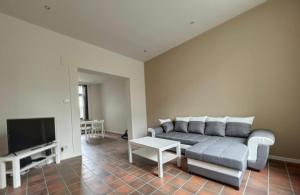 ein Wohnzimmer mit einem Sofa und einem TV in der Unterkunft Station 64 A1 Bruxelles-Charleroi-airport in Charleroi