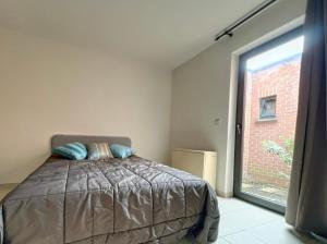 a bedroom with a bed and a large window at Station 64 A1 Bruxelles-Charleroi-airport in Charleroi