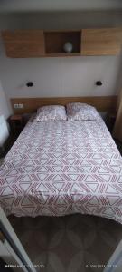 un grande letto in una camera da letto con testiera in legno di mobil home 235 a Pont-Aven