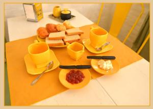 a table with plates of food and cups and bread at Ginkgo Hostel La Plata in La Plata