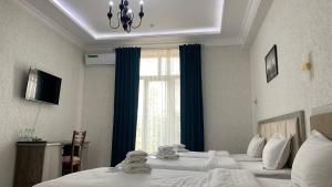 um quarto de hotel com duas camas e uma janela em OLD STATION HOTEL em Samarkand