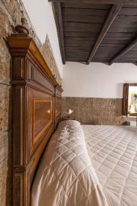 1 dormitorio con 1 cama grande de madera en una habitación en La Rocca - Palazzo Pallotti, en Lubriano