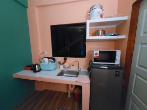 a small kitchen with a sink and a microwave at Danny's Den Boracay in Boracay