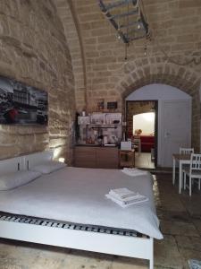 een slaapkamer met een wit bed in een stenen muur bij Lullaby Room in Bari