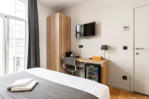 a bedroom with a bed and a desk and a tv at Hotel Het Menneke in Hasselt