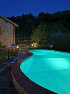 a swimming pool in a yard at night at Casa Caterina in Moncioni