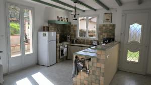 een keuken met een koelkast en een aanrecht bij La noix qui roule in Champagnac-de-Bélair