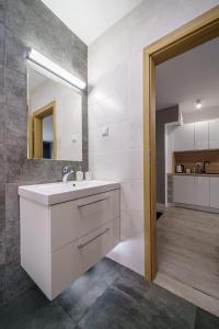 a bathroom with a white sink and a mirror at Apartament9 Źródlana MountainAparts in Świeradów-Zdrój
