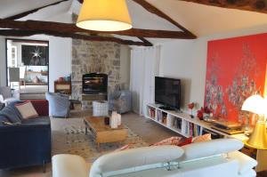 a living room with a couch and a tv at Chambre d'hôtes A la clé des champs Varen in Varen