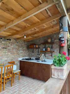 an outdoor kitchen with a sink and a table at Bujtina Salko in Muçaj