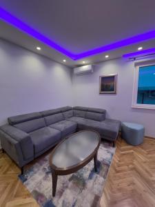 een woonkamer met een bank en een paars plafond bij City Gem: Stylish Urban Hideout in Budva