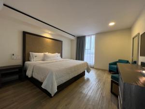 una habitación de hotel con una cama grande y una silla en Hotel Lepanto Reforma, en Ciudad de México