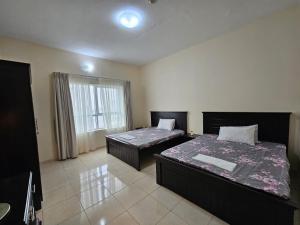 - une chambre avec 2 lits et une fenêtre dans l'établissement ZLEEP, à Ajman
