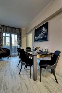 una sala da pranzo con tavolo e sedie e un soggiorno di LUXURY Apartament a Bucarest