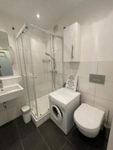 a bathroom with a shower and a toilet and a sink at Premium Studio Grafenberg in Düsseldorf