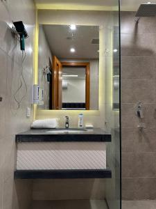 y baño con lavabo y espejo. en Homey Stays - 2 Bedroom Apartment - Gulberg en Lahore