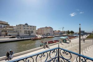 Blick auf einen Fluss mit Booten in einer Stadt in der Unterkunft Casa Marques Apartments in Aveiro