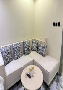 a living room with a couch with pillows and a table at أستديو بدخول ذكي حي الربوة in Riyadh