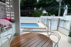 a patio with a table and chairs and a swimming pool at Ampla casa com piscina na Pituba in Salvador