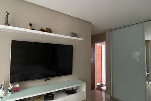 a living room with a large flat screen tv on a wall at Ampla casa com piscina na Pituba in Salvador