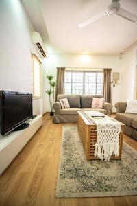 a living room with a couch and a tv at DeLuma-Lovely 4R3B@Kota Permai in Bukit Mertajam