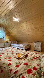 a bedroom with a bed with flowers on it at Chatka Dziadka Sudety in Stary Gieraltow