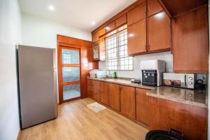 a kitchen with wooden cabinets and a stainless steel refrigerator at DeLuma-Lovely 4R3B@Kota Permai in Bukit Mertajam