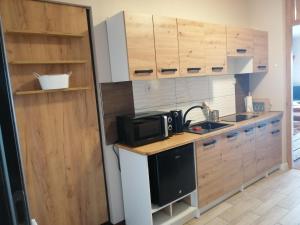 a kitchen with wooden cabinets and a microwave at Agroturystyka Szklana Polana in Huta Szklana