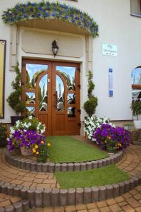 uma porta de um edifício com flores em frente em Hotel Three Korony em Skhidnitsa