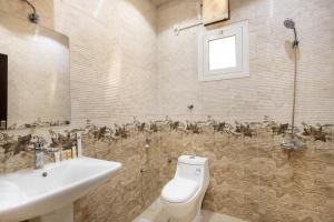 a bathroom with a white toilet and a sink at Al-Jamwaut A - Qaswarah Residence in Medina