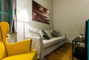 ein Wohnzimmer mit einem Sofa und einem gelben Stuhl in der Unterkunft Cosy Apartment In Party District K30 in Budapest