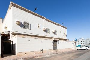 a white building with windows on the side of it at Al-Jamwaut A - Qaswarah Residence in Al Madinah