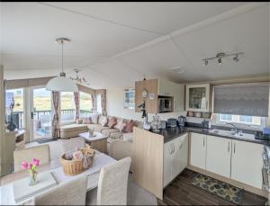 a kitchen and living room with a couch and a table at Peacehaven, Ynyslas, Borth in Borth