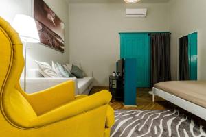 a bedroom with a yellow chair and a bed at Cosy Apartment In Party District K30 in Budapest