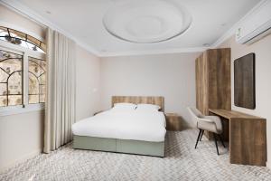 a bedroom with a bed and a desk and a chair at Al-Jamwaut A - Qaswarah Residence in Medina