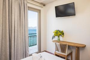 um quarto com uma janela com vista para o oceano em Eftopia Beachfront 3-bedrooms apartment em Kokkari