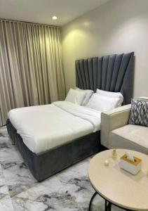 a bedroom with a large bed and a couch at أستديو بدخول ذكي حي الربوة in Riyadh