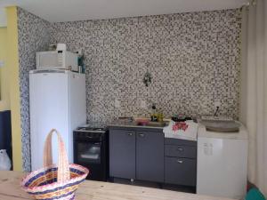 een keuken met een koelkast en een fornuis top oven bij Casa a 550m da praia e 350m da Lagoa da Tapera. in Passo de Torres