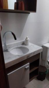 een badkamer met een wastafel en een toilet bij Casa a 550m da praia e 350m da Lagoa da Tapera. in Passo de Torres
