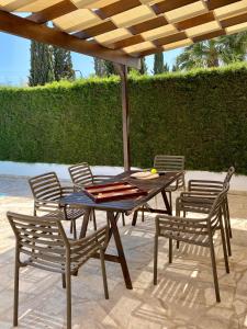 einen Tisch mit Stühlen und einem Sonnenschirm auf einer Terrasse in der Unterkunft Villa Lorena Protaras in Protaras