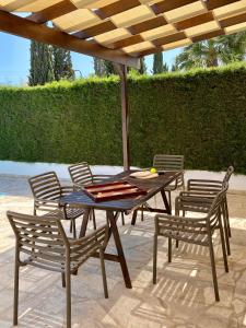 ein Tisch mit Stühlen und einem Sonnenschirm auf einer Terrasse in der Unterkunft Villa Lorena Protaras in Protaras + 19 Fotos