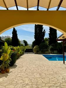 einen Torbogen über eine Terrasse mit einem Pool in der Unterkunft Villa Lorena Protaras in Protaras