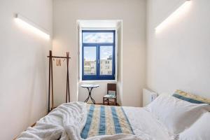 a bedroom with a bed and a window at Casa Marques Apartments in Aveiro