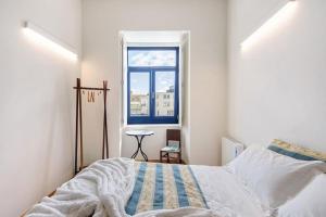 ein Schlafzimmer mit einem Bett und einem Fenster in der Unterkunft Casa Marques Apartments in Aveiro