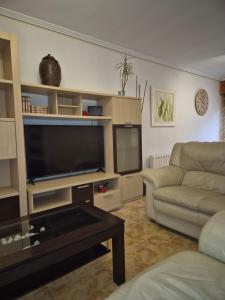 a living room with a couch and a flat screen tv at Adosado playa Rodeira in Cangas de Morrazo