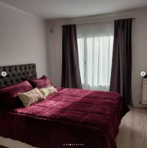 een slaapkamer met een groot paars bed en een raam bij Hermosa y amplia casa nueva in Puerto Madryn