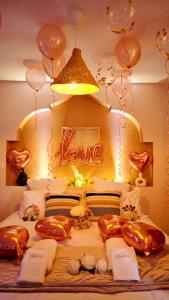 a bed with balloons and a sign that says love at L' Oriental Suite de Luxe in Serrières