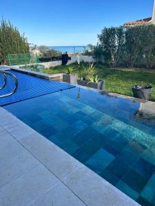 - une piscine avec des carreaux bleus dans l'arrière-cour dans l'établissement COTTAGE MARIN avec VUE MER, à Nice