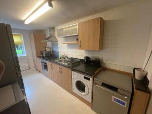 a small kitchen with a washing machine and a washer at Spacious Apartment near Heathrow with Allocated Parking in Uxbridge