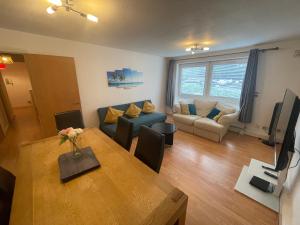 a living room with a couch and a table at Spacious Apartment near Heathrow with Allocated Parking in Uxbridge